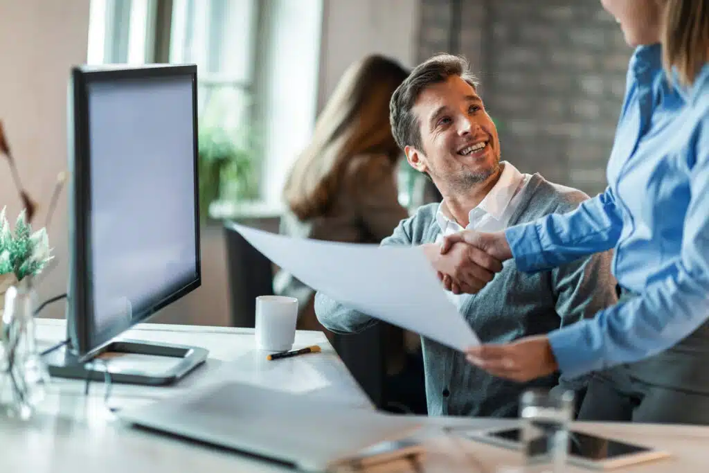 happy-businessman-shaking-hands-with-female-colleague-congratulating-her-excellent-job-she-did